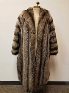 Full Length Raccoon Fur Coat: This full length raccoon fur coat is by an unknown manufacturer and is in great used condition with no known damages. This coat features dark brown linen interior, 2 outside concealed pockets, as