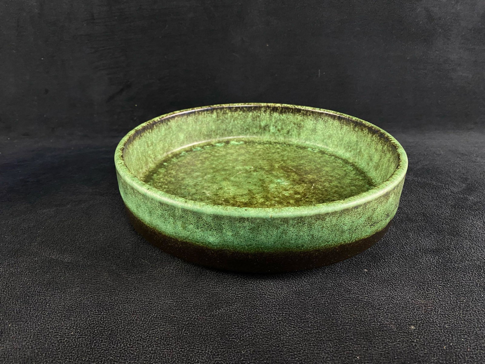 Vintage Green Earthenware Bowl - Germany: Vintage Green Earthenware Bowl - Germany Bowl made in Germany, sometime before 1989. Green glaze over rust colored earthenware clay. No known chips, cracks, or crazing. Approximate size: 9" x 9" x 2.2
