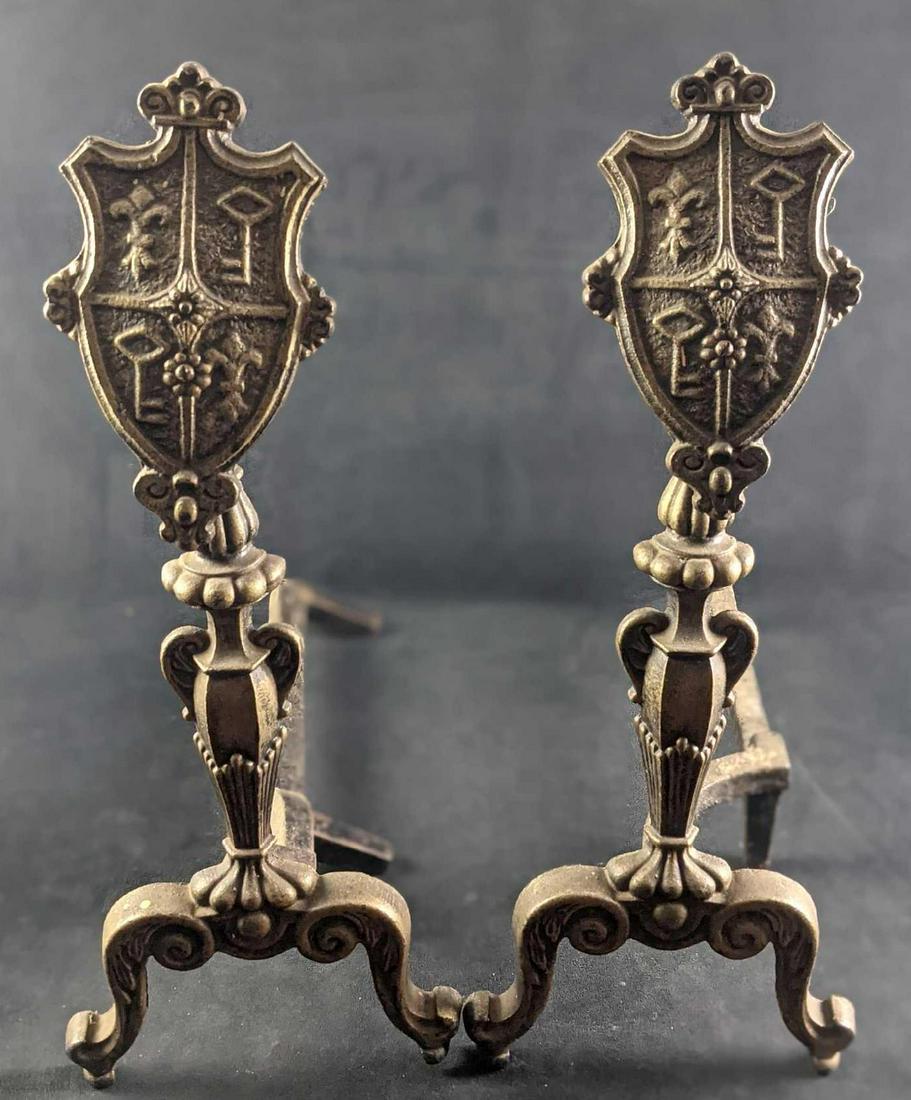Pair Of Wrought Iron Castle Shield Fireplace Andirons: Pair Of Wrought Iron Castle Shield Fireplace Andirons. Each is approx 9" x 19" x 22" and together they weigh 17lbs. The andirons are in a good, vintage condition with some wear, scratches, surface rus
