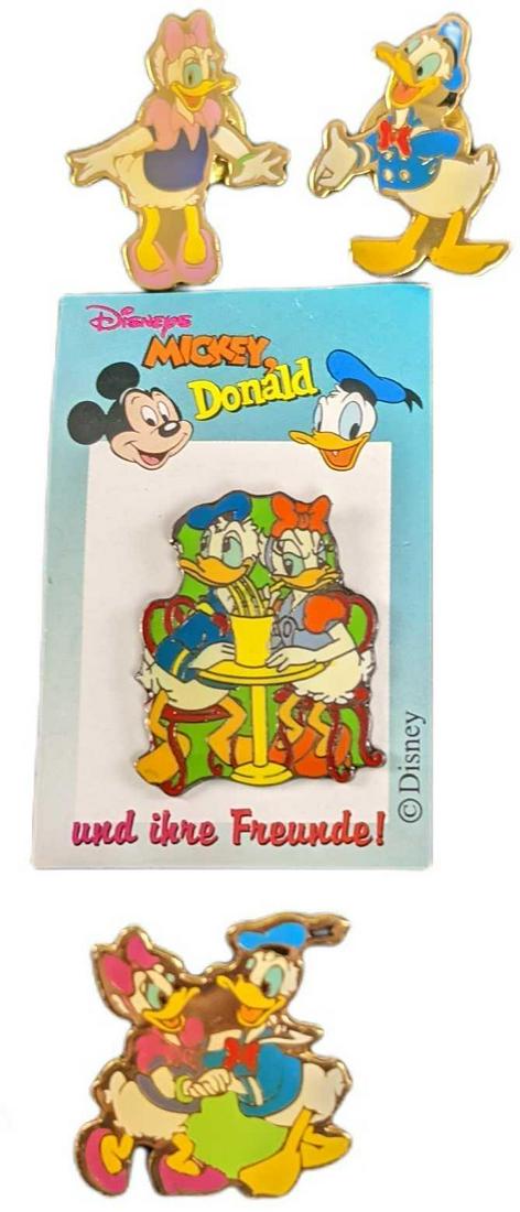 Four Disney Donald & Daisy Duck Pins: This lot includes: (1) Daisy & Donald Duck Sharing A Drink Pin. (German Release). This is approx 1 1/2" x 2 1/4". (1) Donald Duck. This is approx 3/4" x 1". (1) Donald & Daisy Holding Hands. This is a