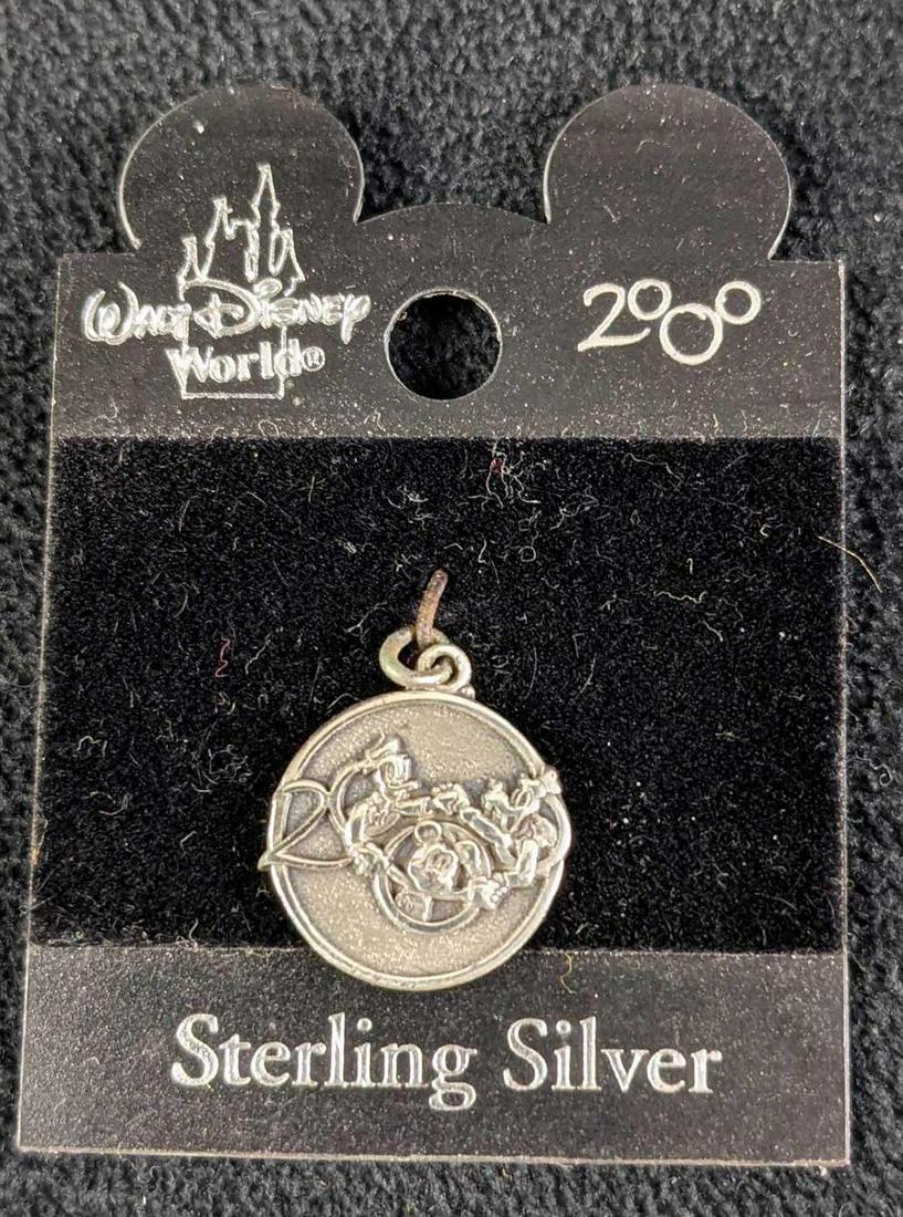 Sterling Silver Walt Disney World 2000 Character Pendant: Sterling Silver Walt Disney World 2000 Character Pendant. A small sterling silver pendant shows Mickey, Goofy, And Donald Duck holding hands along with the year 2000. Which was part of Disney's "Celeb