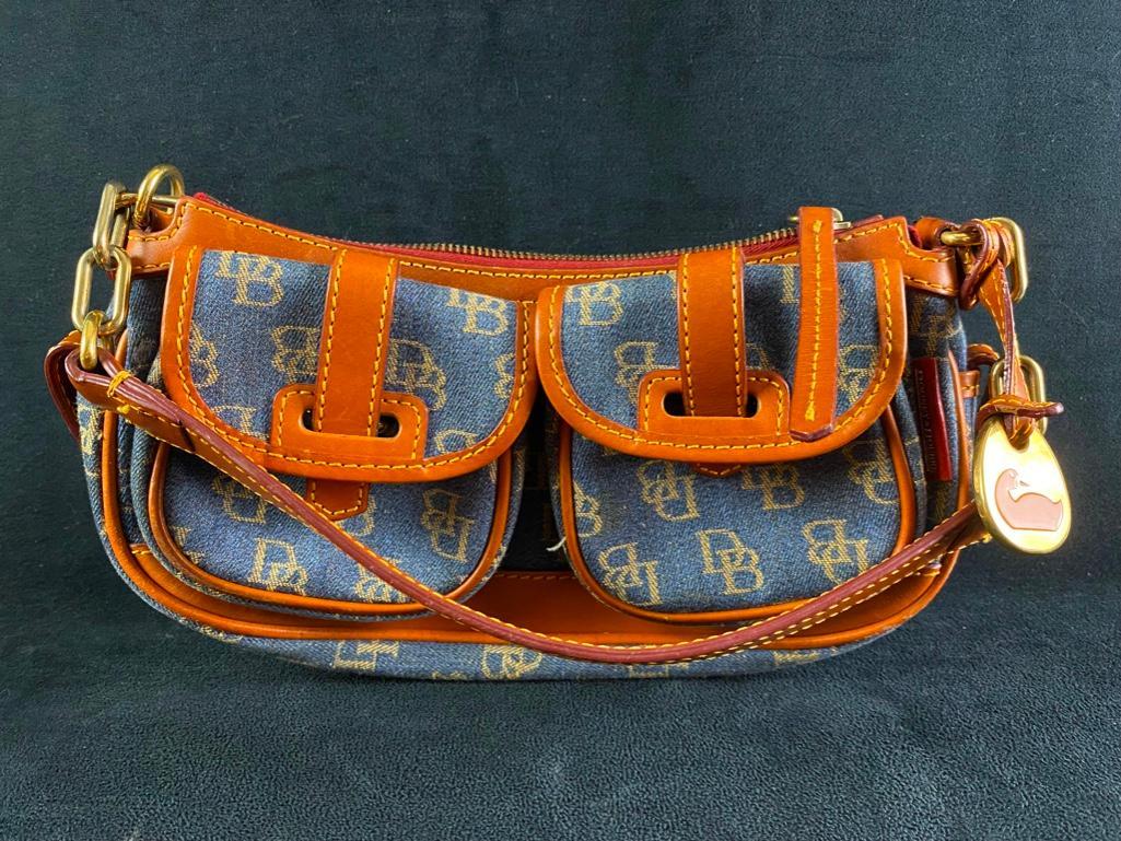 Dooney and Bourke Saddle-Style Handbag: Dooney and Bourke Saddle-Style Handbag Saddlebag-style handbag from Dooney and Bourke in denim with the monogram logo and leather trim. In good condition, with light wear. Approximate size: 12" x 6" x