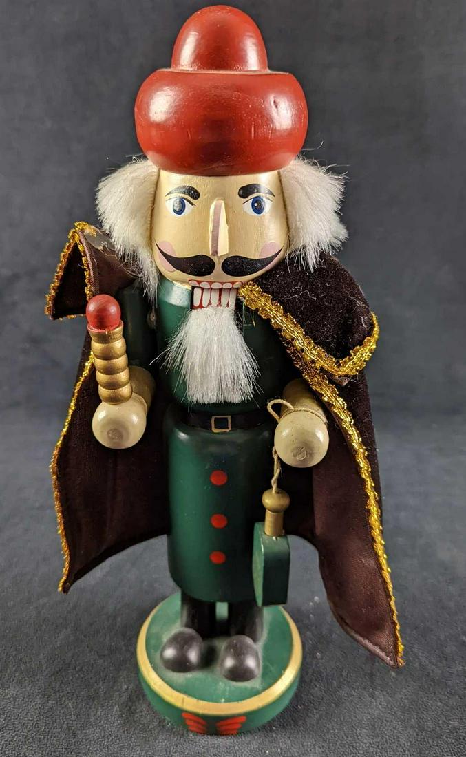Christmas Holiday Wooden Crusader Nutcracker: Caped crusader with red hat and green tunic. There is some glue residue on the cape and the nutcracker is a little loose on base. Please note, this is decoration and not used for cracking nuts. Is app