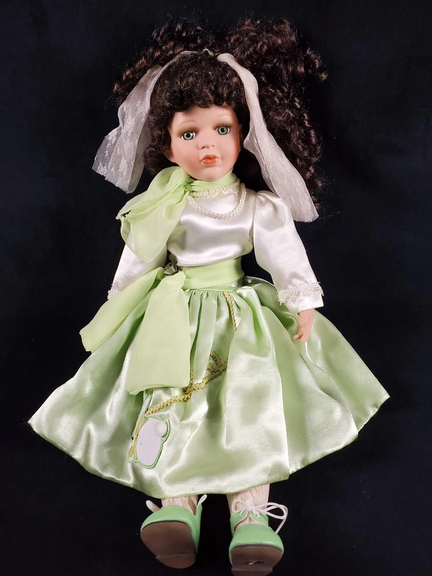 Vintage Wondertreats Porcelain Doll With Curly Hair: Vintage doll by Wondertreats Inc. Comes in an stylish light green 'poodle' type skirt with a white rabbit design. Has plush body and Porcelain limbs and head. Topped with fully intact curly dark hair.