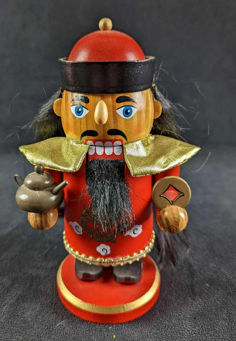 Asian Style Wooden Christmas Holiday Nutcracker: 2010 Asian design on red and gold base. It is holding a symbol and tea pot. Please note, this is for decoration and not for the cracking of nuts. Is approx 4" x 4" x 7 1/2" and it weighs 0.62lb. There