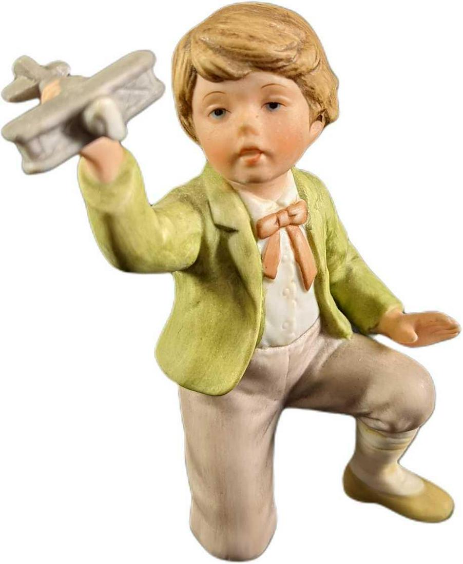 Vintage Figure Boy With Plane: A hand-painted ceramic figure. "Boy With Plane" Has a young boy playing with a toy plane. Stamped 1980 Enesco. The figure is in good, vintage condition with some wearing on the bottom of the base and 