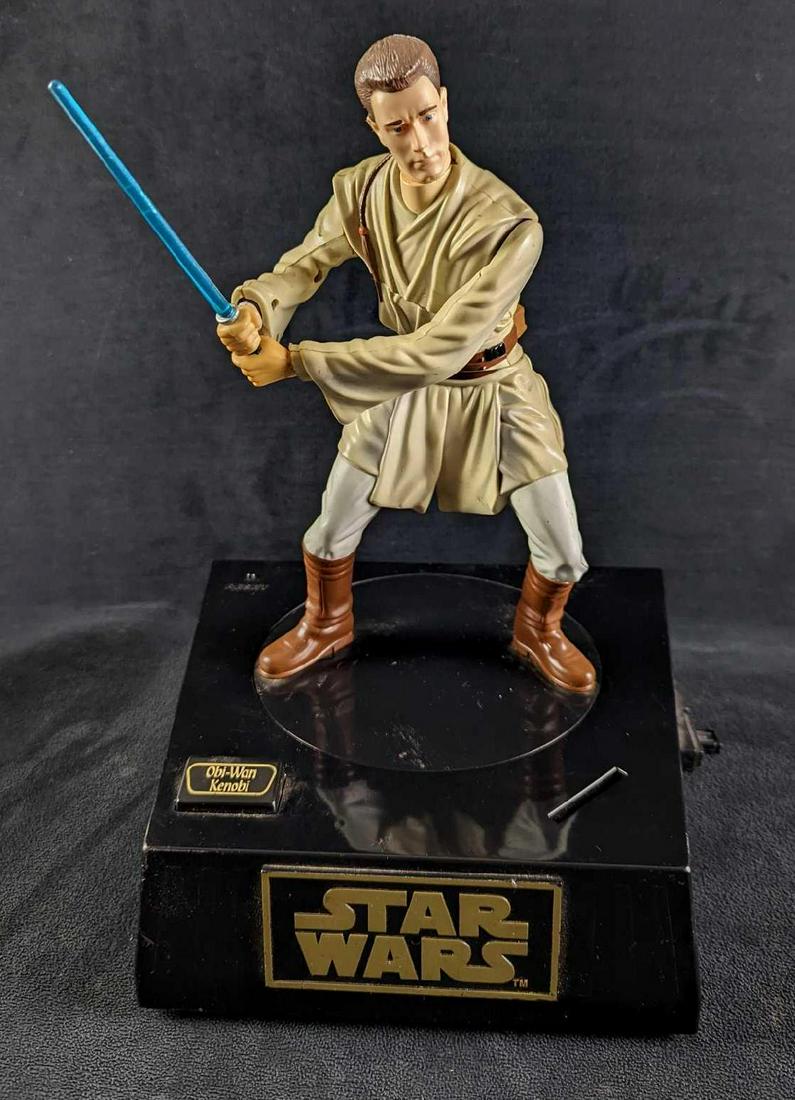 Obi Wan Kenobi Interactive Talking Bank Star Wars: Obi Wan Kenobi Interactive Talking Bank Star Wars. From Phantom Menace. Released in 1999 by Thinkway Toys. The bank is approx 9 1/4" x 8 1/4" x 12 1/2" and it weighs 2.27lbs. Has a latch on the side f