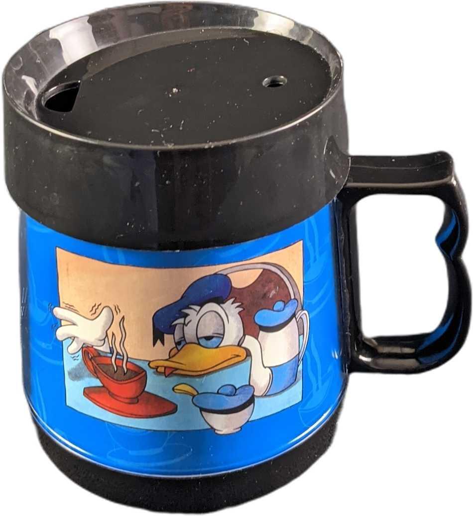 Disney Donald Duck Sleepy Morning Travel Mug: This insulated Donald Duck mug features a half-asleep Donald resting his head on the table while reaching for his morning coffee. It is made out of plastic and the bottom has a foam pad to protect the