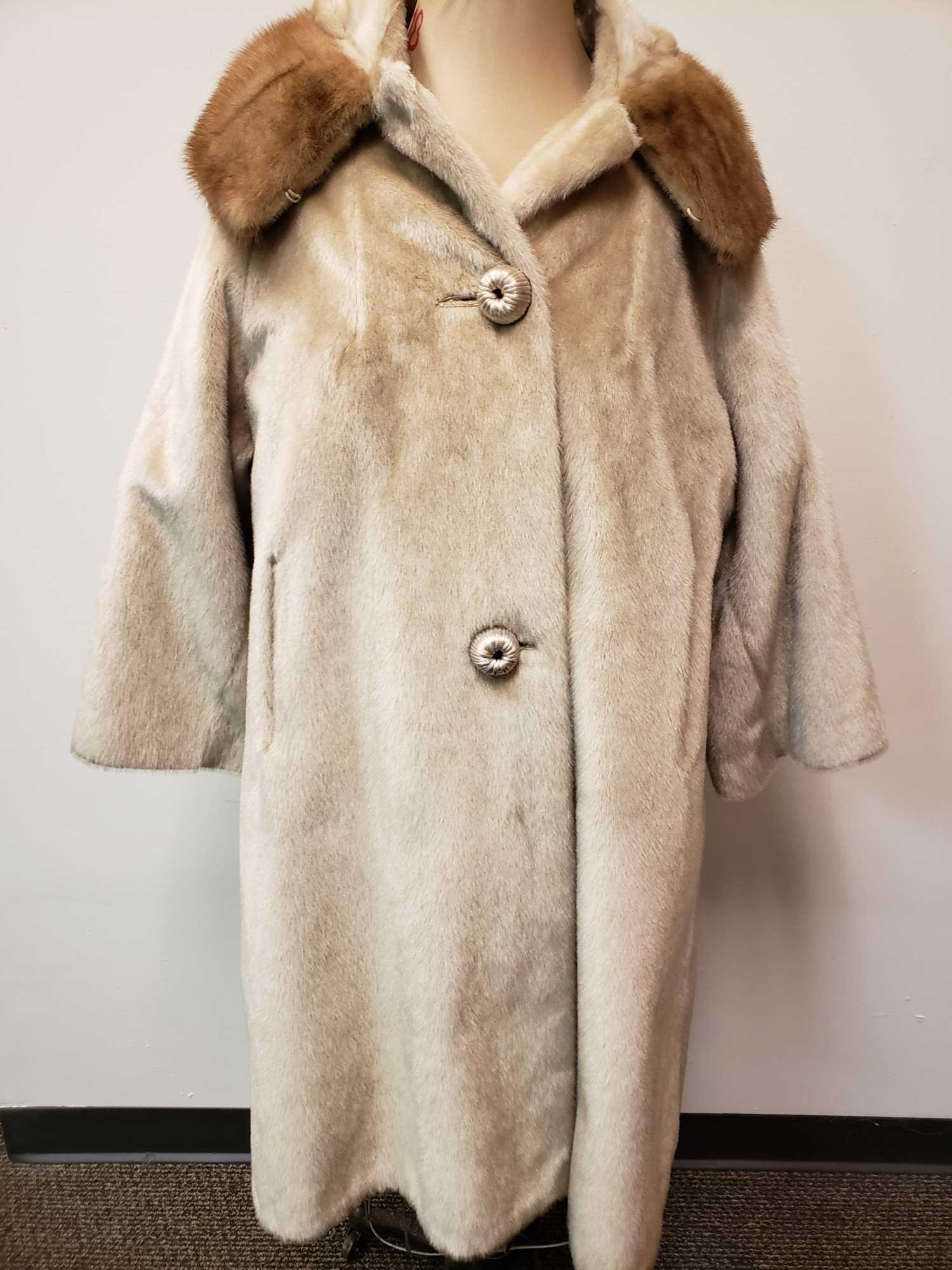 Modelia Full Length Fur Coat with Mink Fur Collar: Modelia Full Length Fur Coat with Mink Fur Collar. This fur coat is in fair used condition. The coat has some staining of the interior lining, the basting stitch on the right hand side has come undone