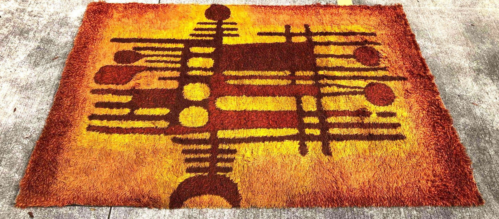 Mid-Century Modern Area Rug By Ege Rya: This lot contains a mid-century modern area rug by Ege Rya. This wild shag rug is filled with vibrant orange hues and a complimenting brown. It is approx 71" x 105" and weighs about 14.5lbs. The rug i