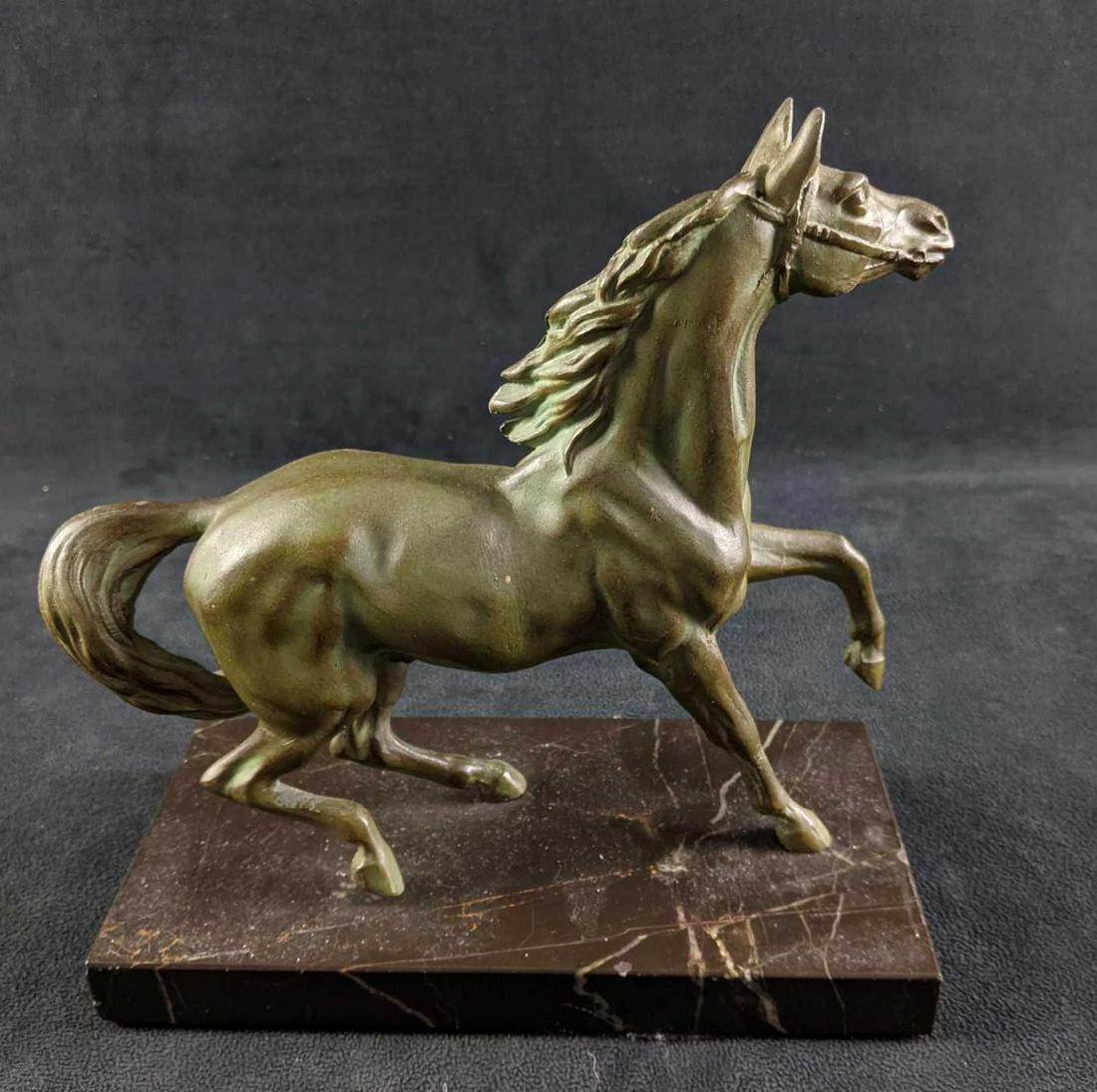 Metal Horse Statue On Black Marble Base: Metal Horse Statue On Black Marble Base This is a metal horse statue a painted on green patina. The statue is mounted on a marble base. This piece is in good condition with only small scratches and no