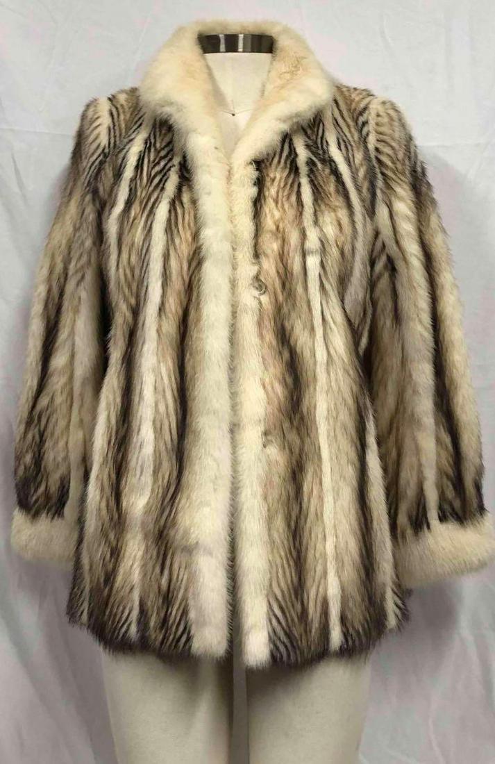 H. Goodman Women's Mid Length Fitch Ferret Fur Coat: This lot contains an H. Goodman mid length Fitch ferret fur coat. This coat features three hook and loops for closure, cuffed sleeves, two exterior pockets and gray/brown silk interior. This coat is i