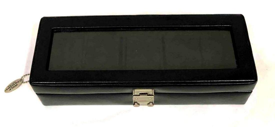 Genuine Leather Watch Display Case By Wolf Designs Since 1834: This lot contains a genuine leather watch display case by Wolf Designs Since 1834. It is approx 11 1/2" x 4" x 3" and weighs about 1.5lbs. Overall the display case is in good used condition with some