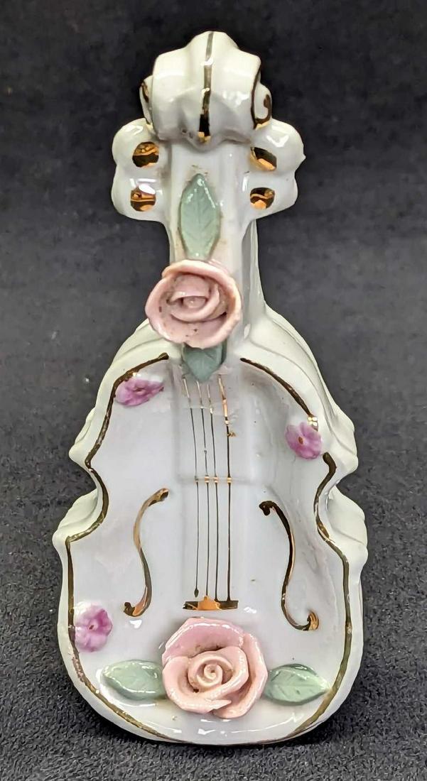 Vintage Bone China Violin Ring Holder Figurine: Vintage Bone China Violin Ring Holder Figurine. Can be used as a figurine, or lay it down and it can be used as a ring holder. This is approx 2" x 1 1/4" x 4 3/4" and it weighs 0.14lb. Has small marki
