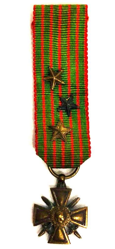 Mini Croix De Guerre WWI Medal 1914-1918: The Croix De Guerre medal. This medal was awarded to French and allied soldiers who were cited for bravery during their service in World War 1. Attachments signify degrees awarded based on actions of