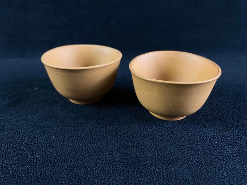 Two Sake Cups: Two Earthenware Sake Cups Set of two sake cups in tan earthenware. The matte earthenware finish and subtly flared rims make these cups a simple yet beautiful choice for enjoying any sake. In good con
