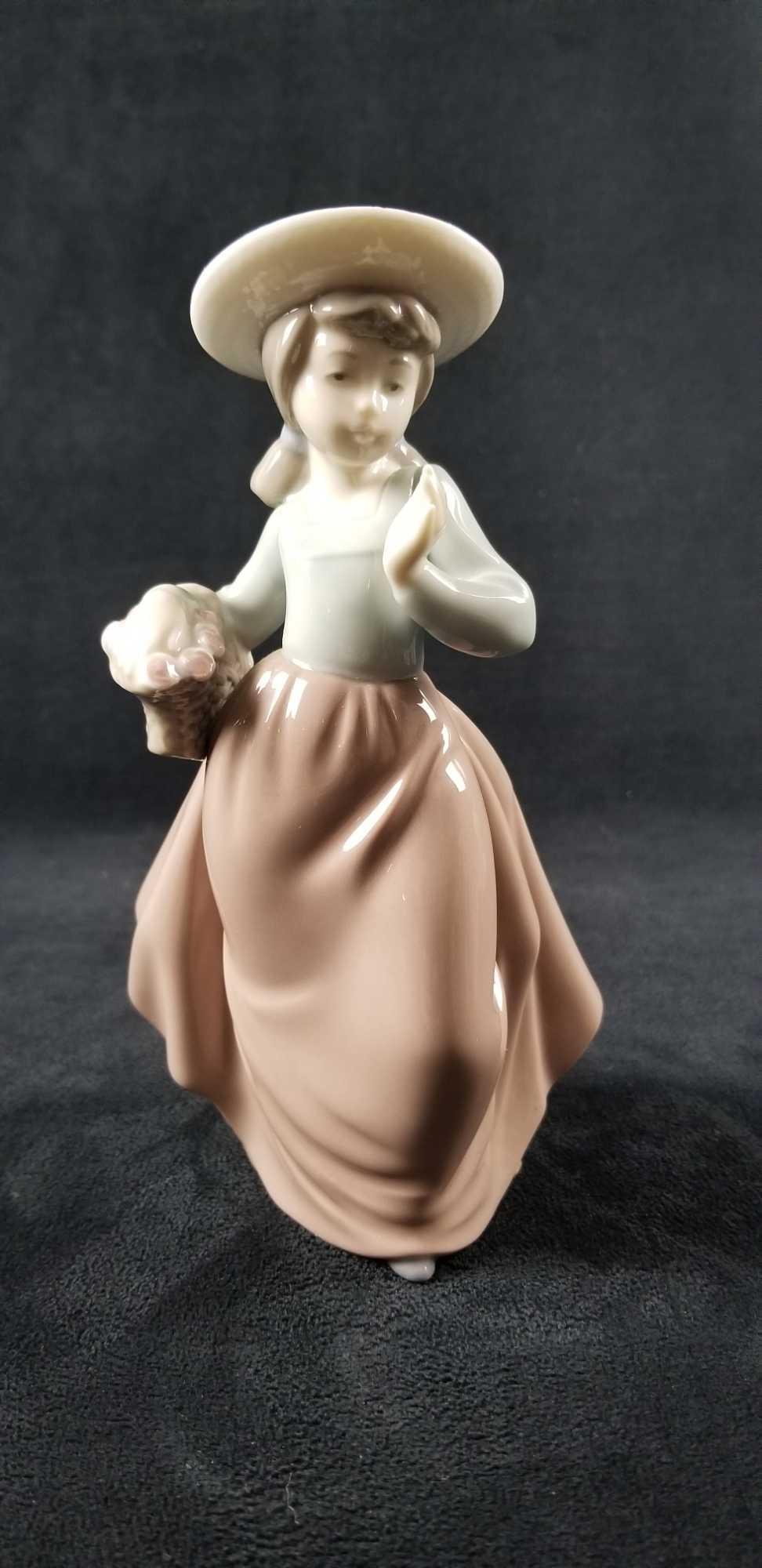Girl with Flower Basket Nao by Llardo: "Girl With Flower Basket" porcelain figurine Nao by Llardo, unknown date or pattern number. This is a colorful glossy girl in a light blue shirt, mauve colored skirt and hat. Maker stamp on bo
