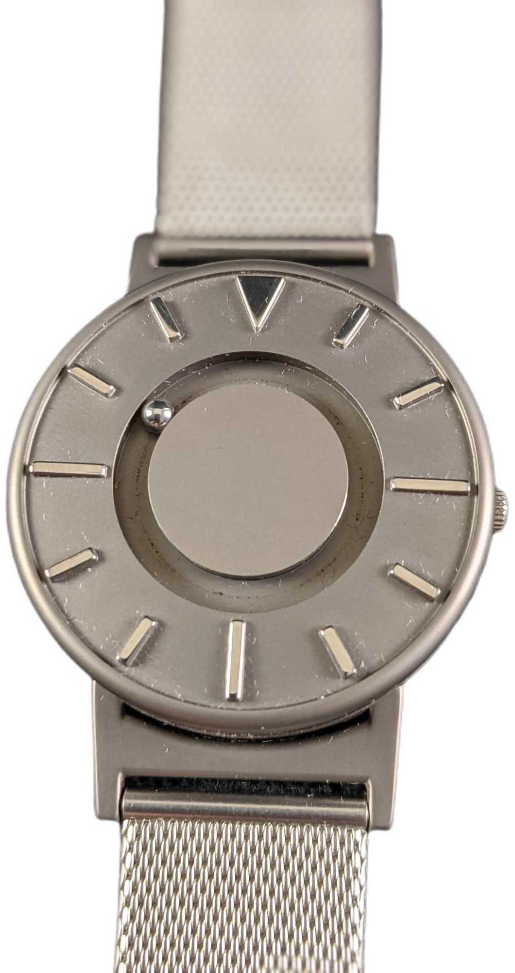 Eone Bradley Steel Mesh Watch: The minimalist face of The Bradley Mesh features raised hour markers brushed in a smooth mirrored finish. The pure titanium case body adds an air of elegance and durability to the piece. The stainless