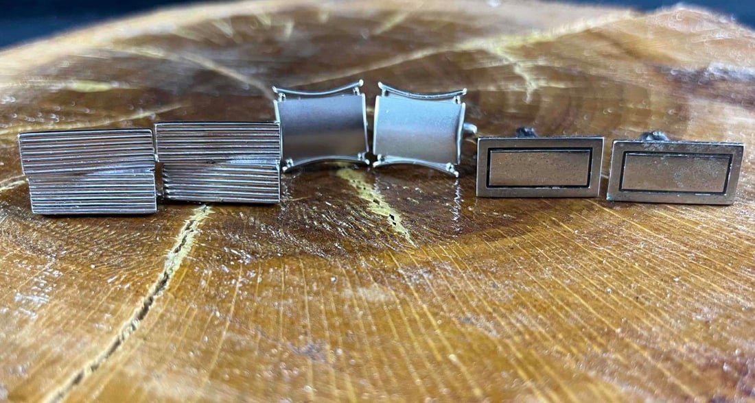 Three Sets of Cufflinks Silver Colored Cufflinks: Three Sets of Cufflinks Silver Colored Cufflinks This lot has three sets of silver-colored cufflinks, all with different designs. These are 80s and 90s style cufflinks, so their designs are from their