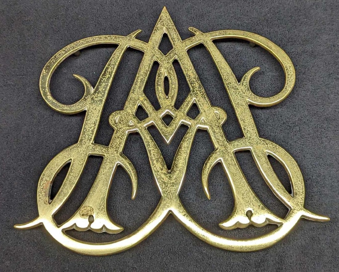 Vintage 1950 Queen Anne Cypher Brass Trivet: Vintage 1950 Queen Anne Cypher Brass Trivet. Made in Williamsburg, Virginia. Is approx 10 3/8" x 1" x 9" and weighs 1.68lb. Trivet is in a good, vintage condition with light surface tarnis