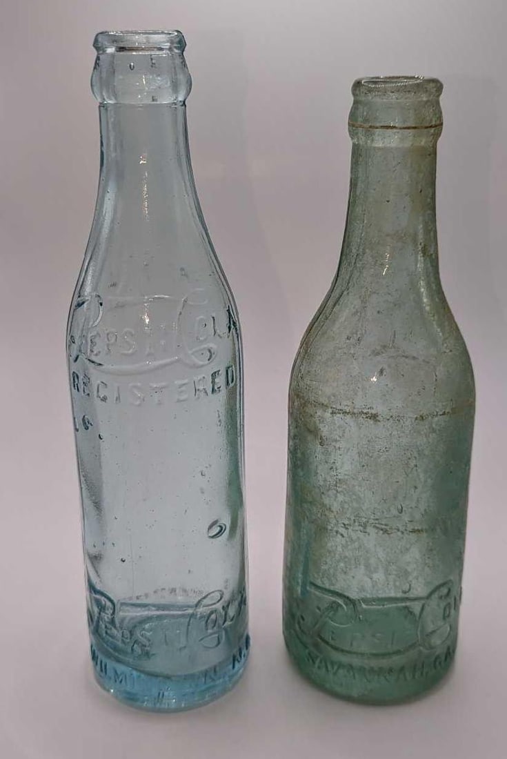 2 Vintage Pepsi Cola Glass Bottles: 2 Vintage Pepsi Cola Glass Bottles. This lot includes: (1) Vintage 7 Oz Pepsi Cola Glass Bottle. From Wilmington, NC. This is approx 2 1/2" x 2 1/2" x 8 1/2". The glass bottle has some bu