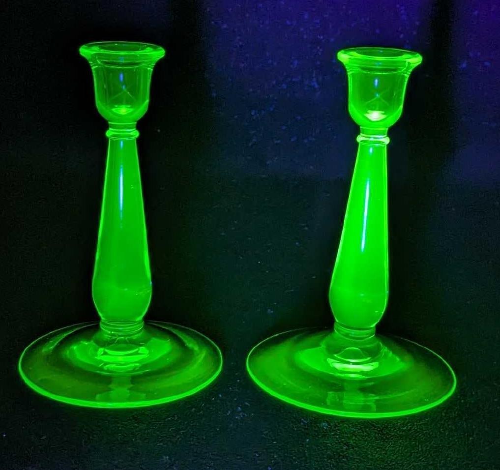 2 Vintage Uranium Glass Green 7" Candlesticks: 2 Vintage Uranium Glass Green 7" Candlesticks. Each is approx 4 1/4" x 4 1/4" x 7" and the total weight is 1.18lb. The glass has some bubbles. Please note, the first image was taken wi