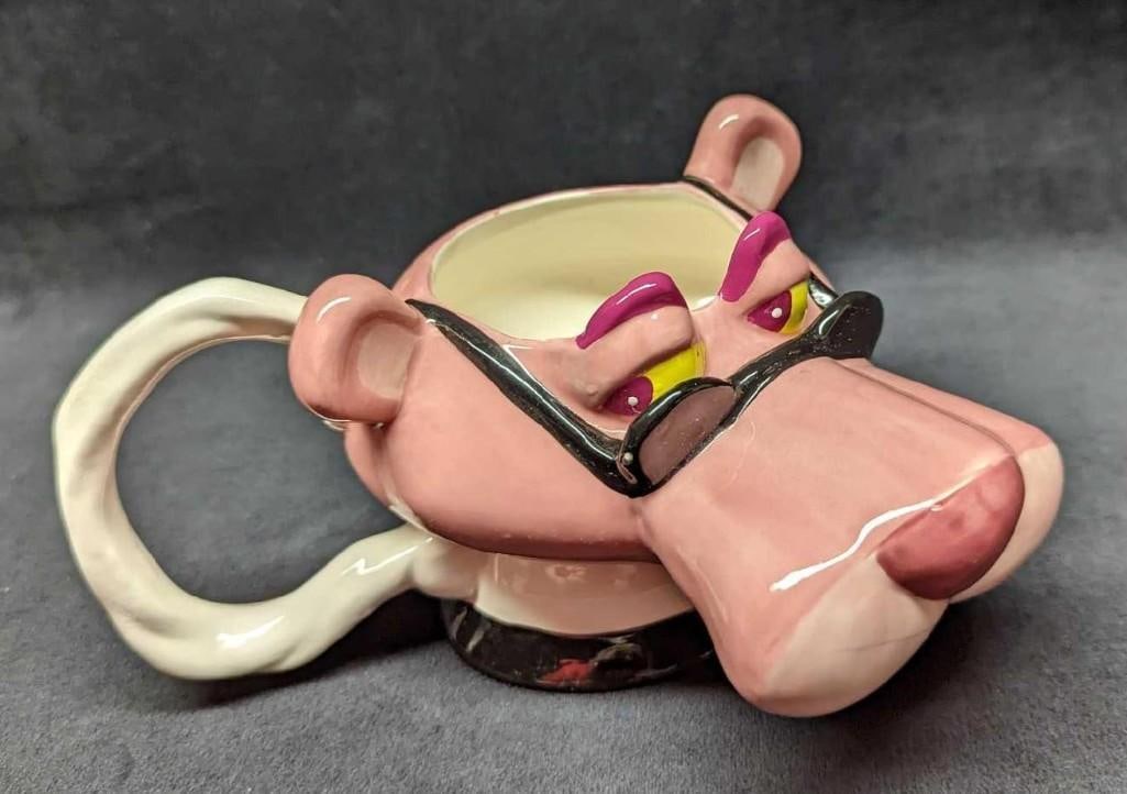 Ceramic Pink Panther With Sunglasses Mug: Ceramic Pink Panther With Sunglasses Mug. This was released by Vandor in 1999. The mug is approx 7" x 5" x 3 3/4" and it weighs 0.77lb. The mug is in good, used condition with a small whit
