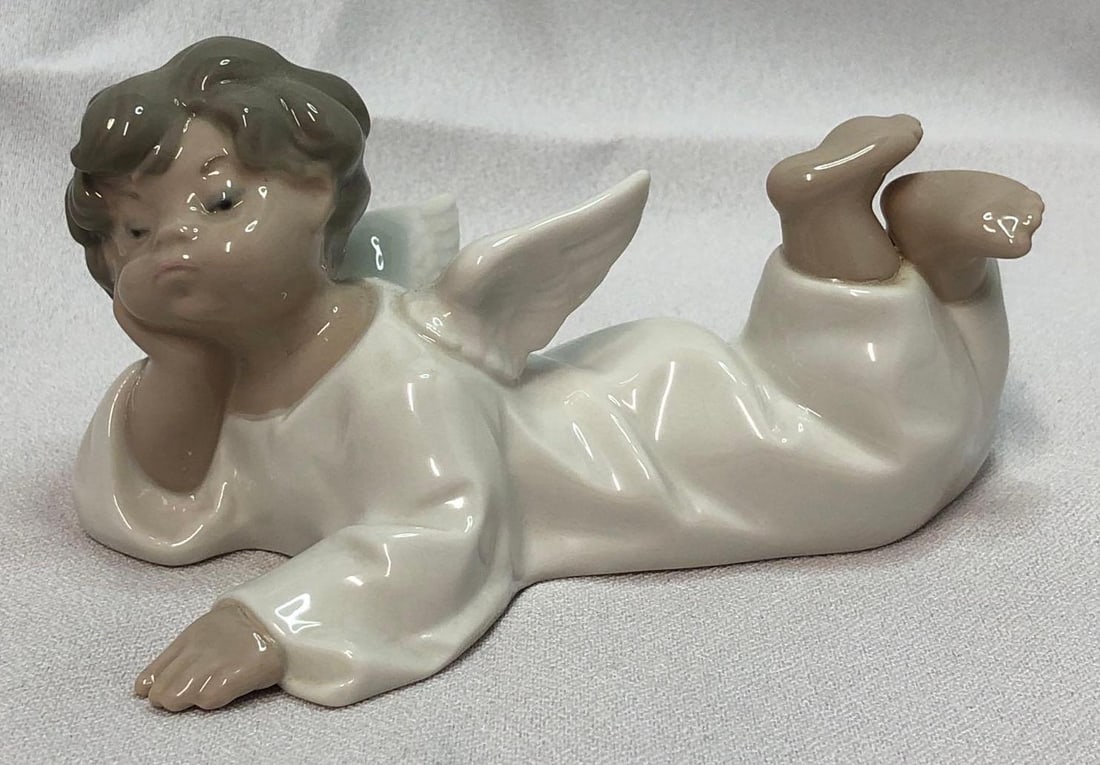 1970 Lladro 4541 Angel Laying Down: This lot contains a 1970 Lladró 4541 Angel Laying Down. Retired in 2005. Handmade in Spain. It is approx 5-1/2" x 2-1/2" x 4" and it weighs about 0.5lbs. Overall the Lladró is in good us