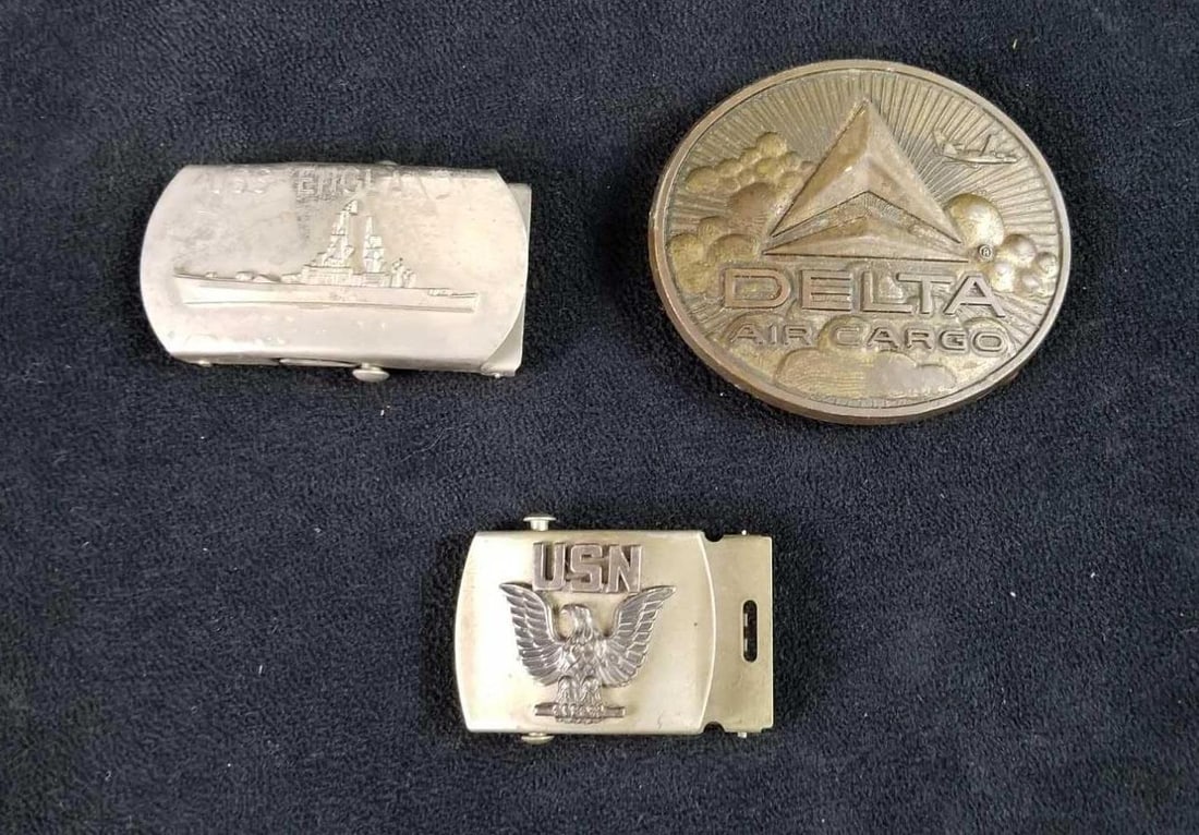 Military and Airline Metal Belt Buckles: This lot contains 3 belt buckles: 1- Oval, "Delta Air Cargo", approx. measures 3 1/2" x 2 3/4" x 1/8" 1- USN Military, slide, approx. measures 2 "x 1 1/2" x 1/2" 1- USS