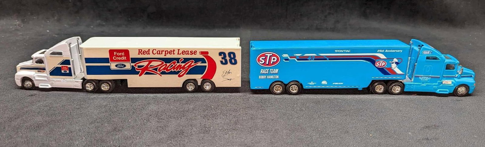 2 Die Cast Bobby Hamilton & Elton Sawyer Race Transport: 2 Die Cast Bobby Hamilton & Elton Sawyer Race Transport. This lot includes: (1) Racing Champions Bobby Hamilton STP Transporter. This is approx 2" x 11" x 2 1/2" and it weighs 1.35lb. 