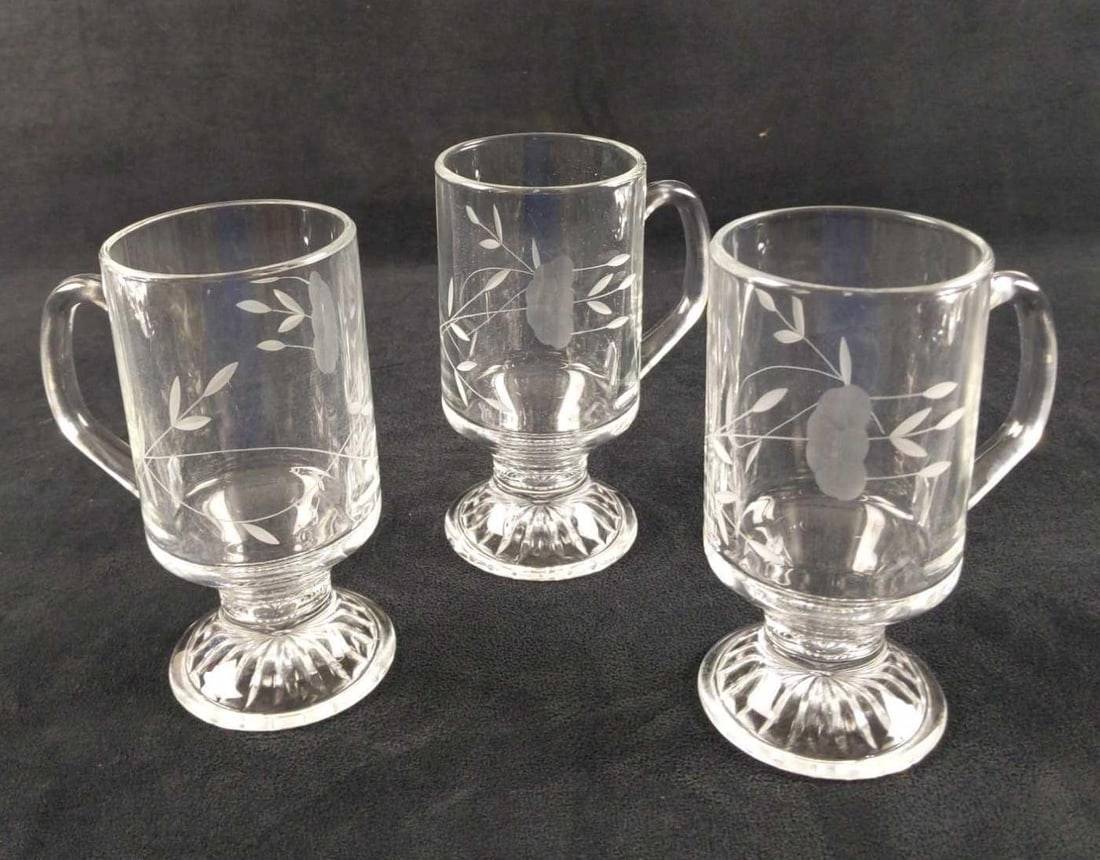Three Heritage By Princess House Irish Coffee Cups B: Three Heritage By Princess House Glass Irish Coffee Cups. Each has a flower etched on its sides. Glasses are approx 4" x 2 3/8" x 5 1/2". Glasses are in good, unused condition with no know