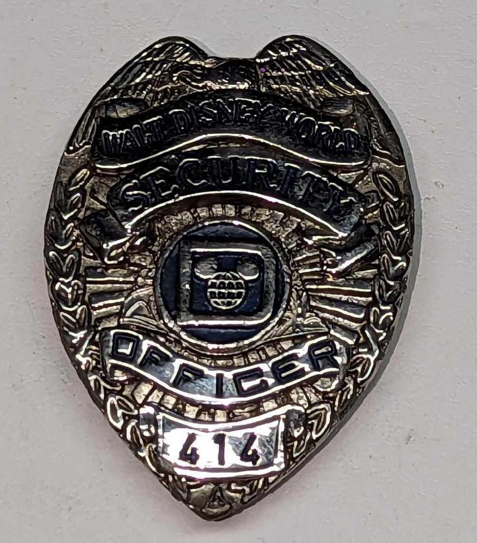 Early 1980s Disney World Female Security Badge 414: Early 1980s Disney World Female Security Badge 414. Is approx 1 3/4" x 1/4" x 2 3/8" and it weighs under one pound at 0.10lb. The metal badge is in a good, vintage condition with some scra