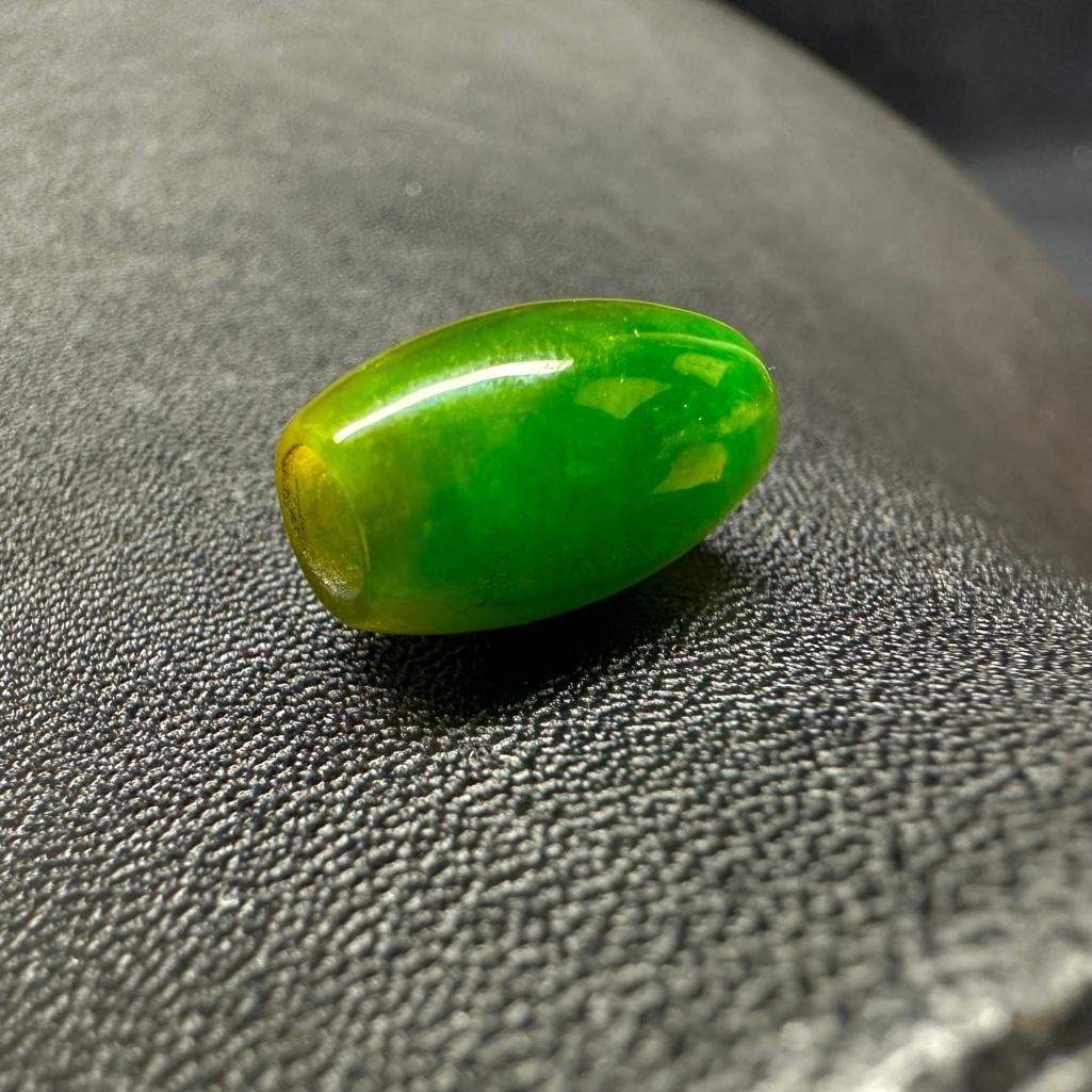 Jadeite Barrel Bead: This piece of jewelry has been tested and researched prior to listing. Please view all our pictures they are part of our description. DETAILS: Metal - none Color - Emerald green, with two yellowish s