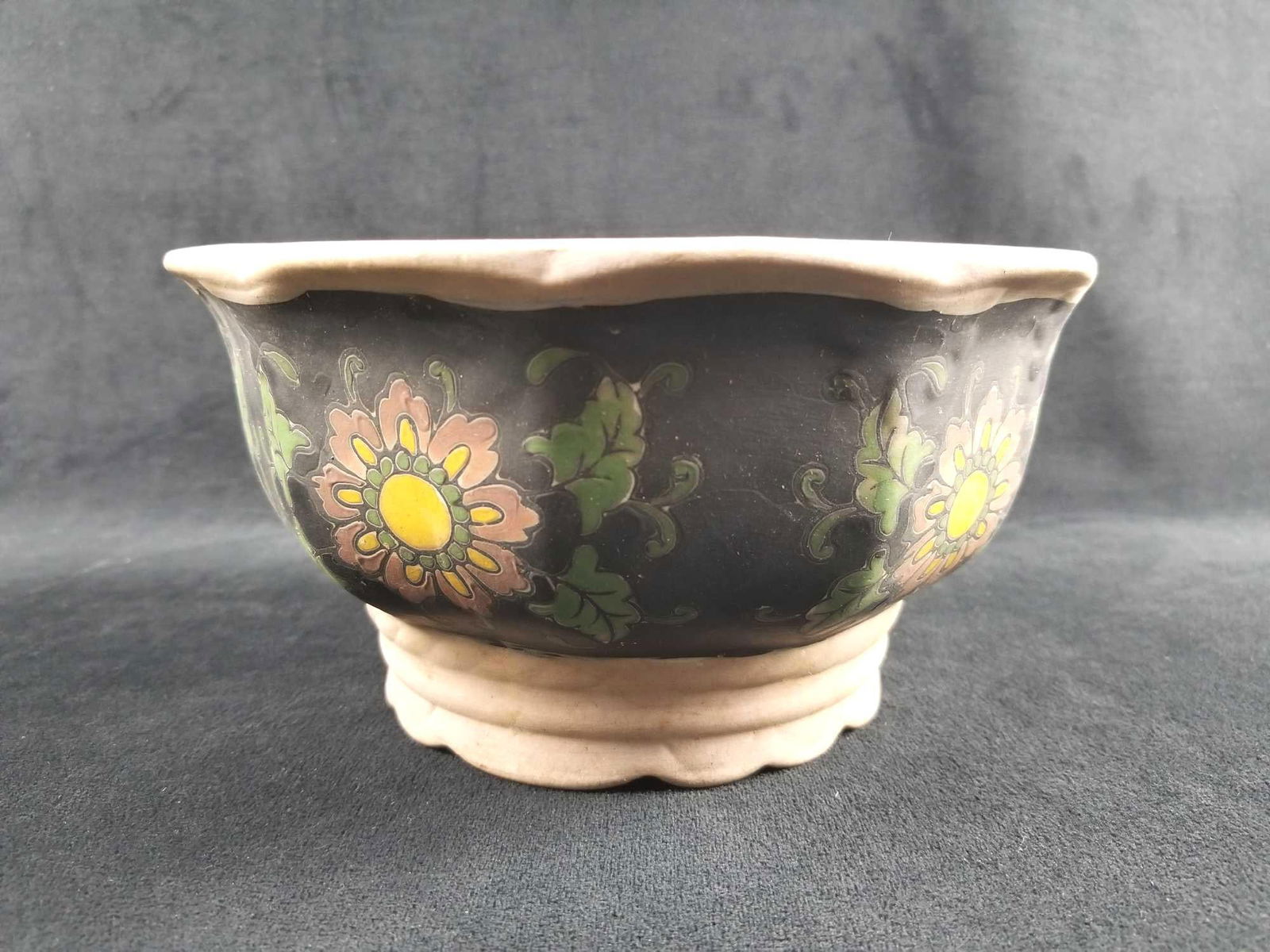Decorative Clay Floral Pot: This is a clay pot that can be used for floral arrangements and gardening. It features floral and leaf designs around the center of the bowl. It is in good condition with no known chips or cracks. It