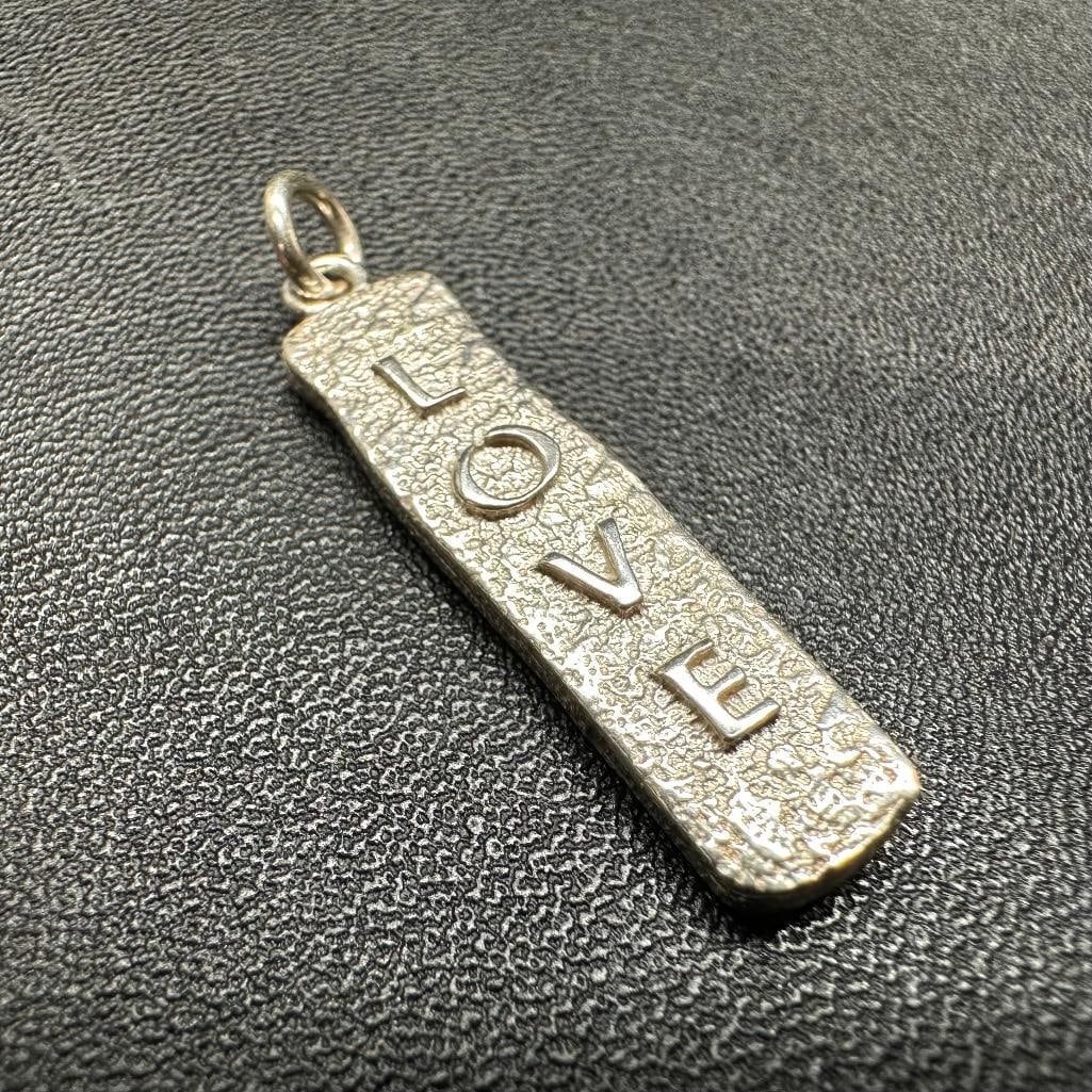 Sterling Silver "Love" Pendant: This piece of jewelry has been tested and researched prior to listing. Please view all our pictures they are part of our description. DETAILS: Metal - Sterling Silver Color -Silver Stones - none Hallm