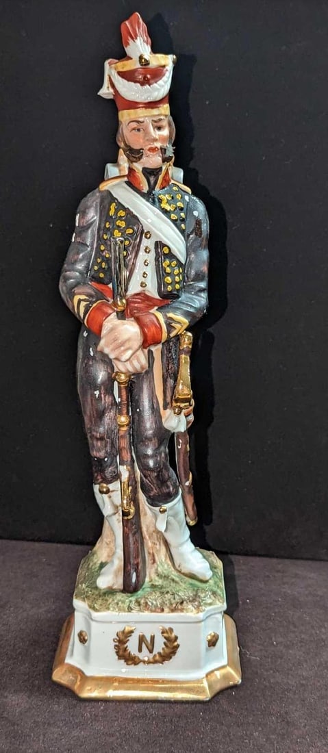 Vintage Capodimonte Corporal Grenadier Figurine JB: Vintage Capodimonte Corporal Grenadier Figurine JB. This is approx 3 3/4" x 3 3/4" x 12 1/2" and it weighs 1.58lb. The figurine has some color loss and wear. Please see the images as they 