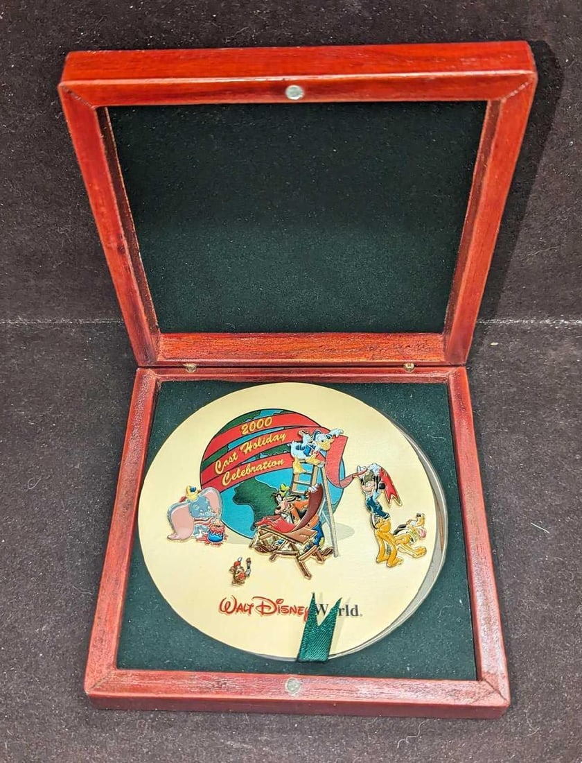 Disney World 2000 Cast Holiday Celebration Pin Set: Disney World 2000 Cast Holiday Celebration Pin Set. Comes with five different pins in a wooden box. Was originally only given to Walt Disney World employees. Comes in its original cardboard box which 