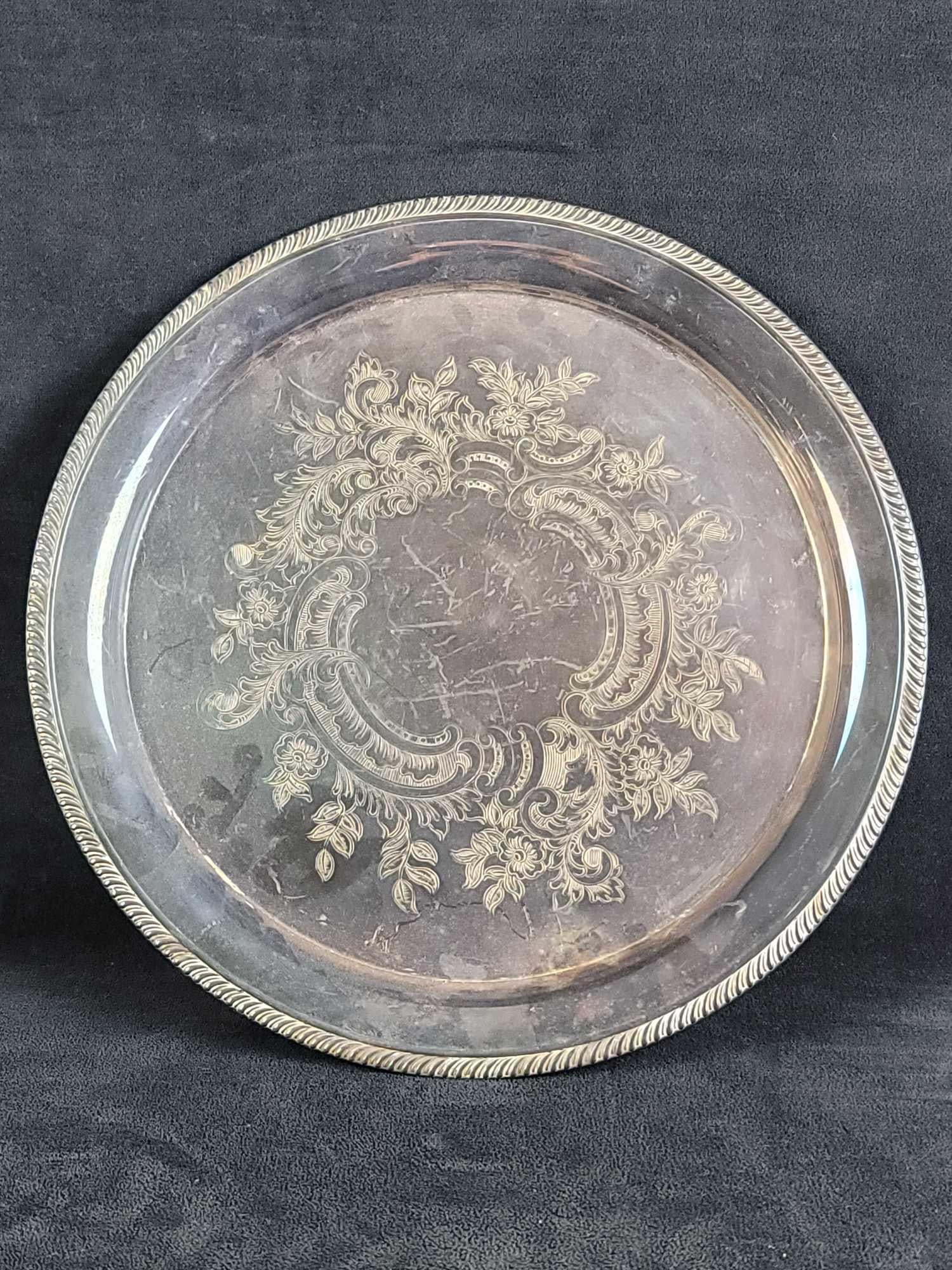 Lunt Silversmiths Round Gadroon Trim Serving Tray: Lunt Silversmiths Round Gadroon Trim Serving Tray has an ornate floral pattern on the center portion. Stamped on the bottom Lunt Silversmiths M-4-EG. In good vintage condition, needs polishing, has so