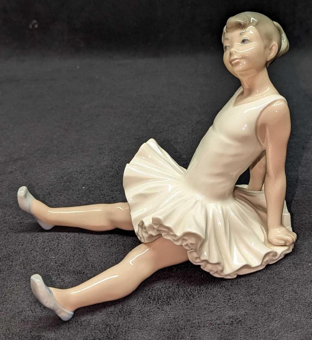 Nao By Lladro Sitting Ballerina Figurine: Nao By Lladro Sitting Ballerina Figurine. This is approx 4 1/2" x 7 1/2" x 5 5/8" and it weighs 1.10lb. The figurine has no chips or cracks. The figurine makes a rattling sound when moved.