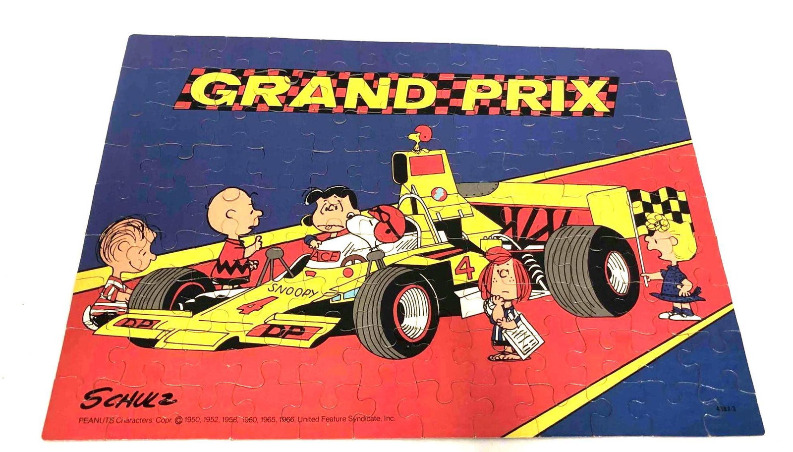 Vintage Peanuts Series Grand Prix MB Puzzle 100 Pieces 1950-60: This lot contains a Vintage Peanuts Series Grand Prix MB Puzzle 100 Pieces 1950-60. It is approx 11 1/4" x 7 1/2" x 1 3/4" and weighs about 0.4lbs. Overall the Puzzle is in good used condition with so