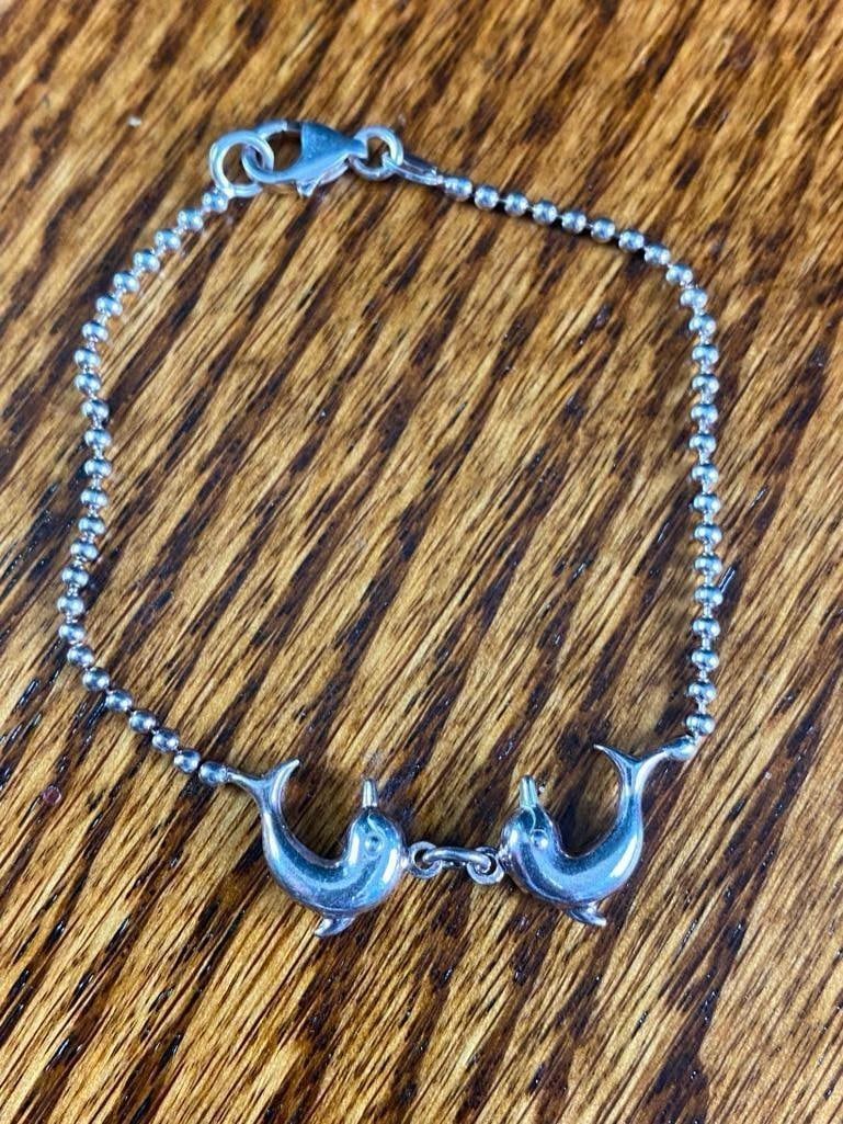 Dolphin Charm Bracelet: Dolphin Charm Bracelet This piece of authentic fine jewelry has been tested and researched prior to listing. Please view all our pictures they are part of our description. DETAILS: Metal - .925 Si