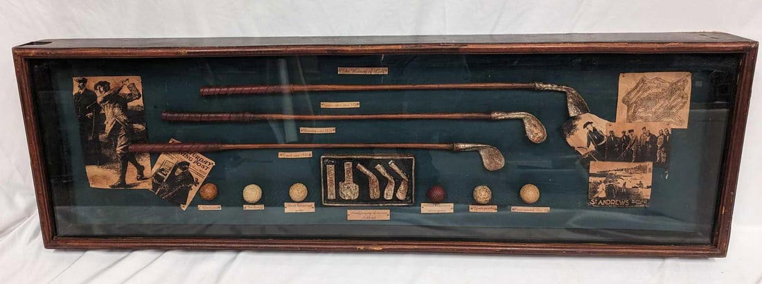 History Of Golf Shadowbox: History Of Golf Shadowbox. Large shadow box featuring element of the history of golf, three clubs, six balls, and five club heads. The shadowbox is approx 41 3/4" x 3 1/4" x 13" and it wei