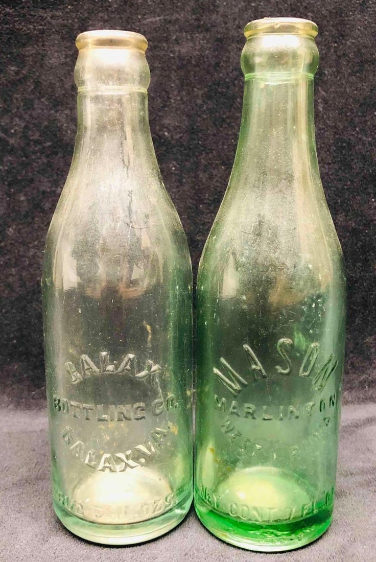 Galax Bottling Co Galax. VA. 6 1/2 Fl Oz. & Mason Marlinton West Virginia 7 Fl Oz.: This lot contains a Galax Bottling Co Galax. VA. 6 1/2 Fl Oz. & Mason Marlinton West Virginia 7 Fl Oz. The Green is approx 2 1/4" x 2 1/4" x 7 3/4" and the clear bottle is approx 2 1/4