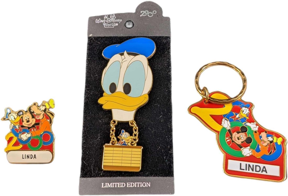 Disney Linda Keychain & Pin W Donald Duck Balloon Pin: This lot includes: (1) Metal Linda 2000 Disney Keychain. This is approx 3 3/4" x 1 1/4". (1) Linda 2000 Disney Pin. This is approx 1" x 1 1/4". (1) Donald Duck Balloon