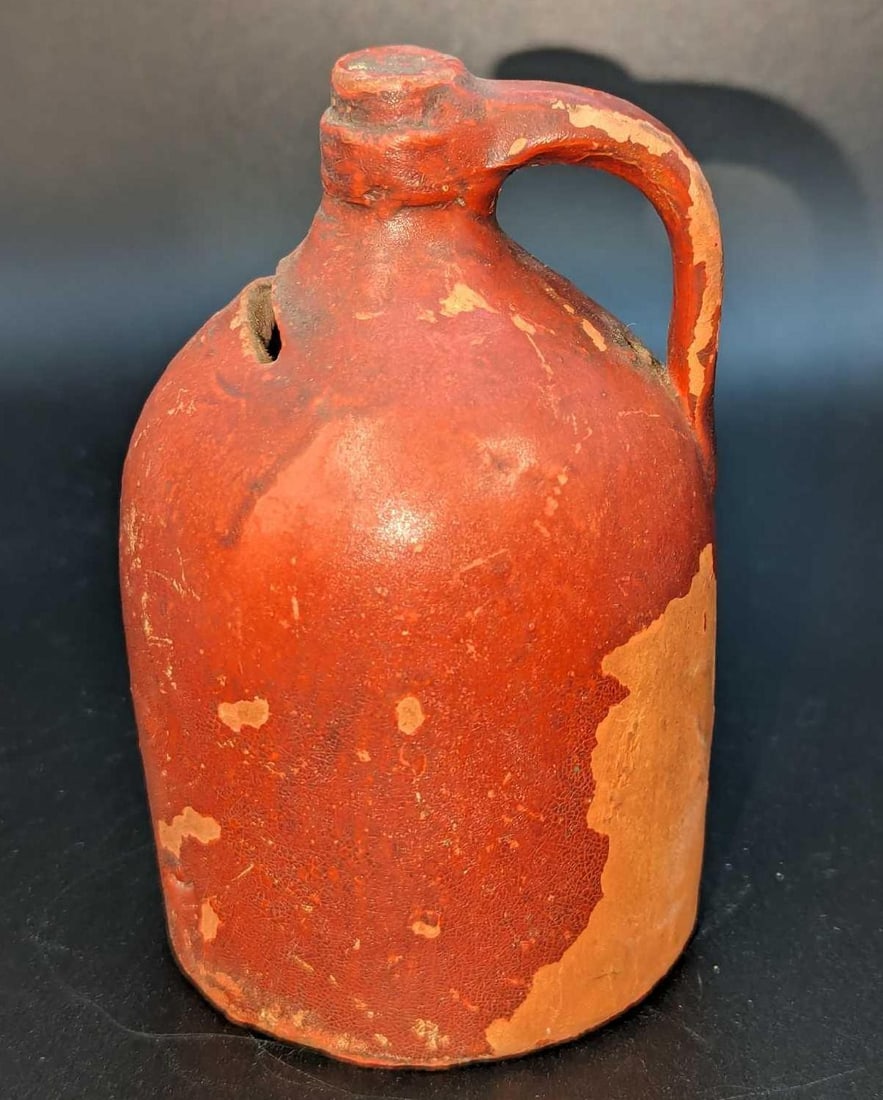 Antique Redware Jug Coin Still Bank: Antique Redware Jug Coin Still Bank. This is approx 3" x 3" x 4 1/2" and it weighs 0.59lb. The bank has some small chips and wear and missing/worn patina. Please see the images as they are