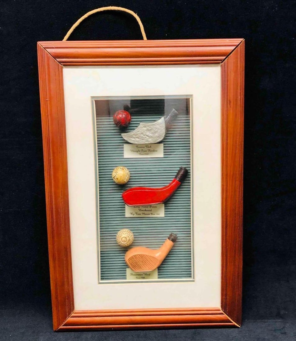 Vintage Golfers Shadow box The History Of Golf: This lot contains Vintage Golfers Shadow box The History Of Golf. The box features three Vintage Clubs & Golf Balls On Display. The Classic Club Wrought Dron Flanders Circa 1420, Long Nosed Driver
