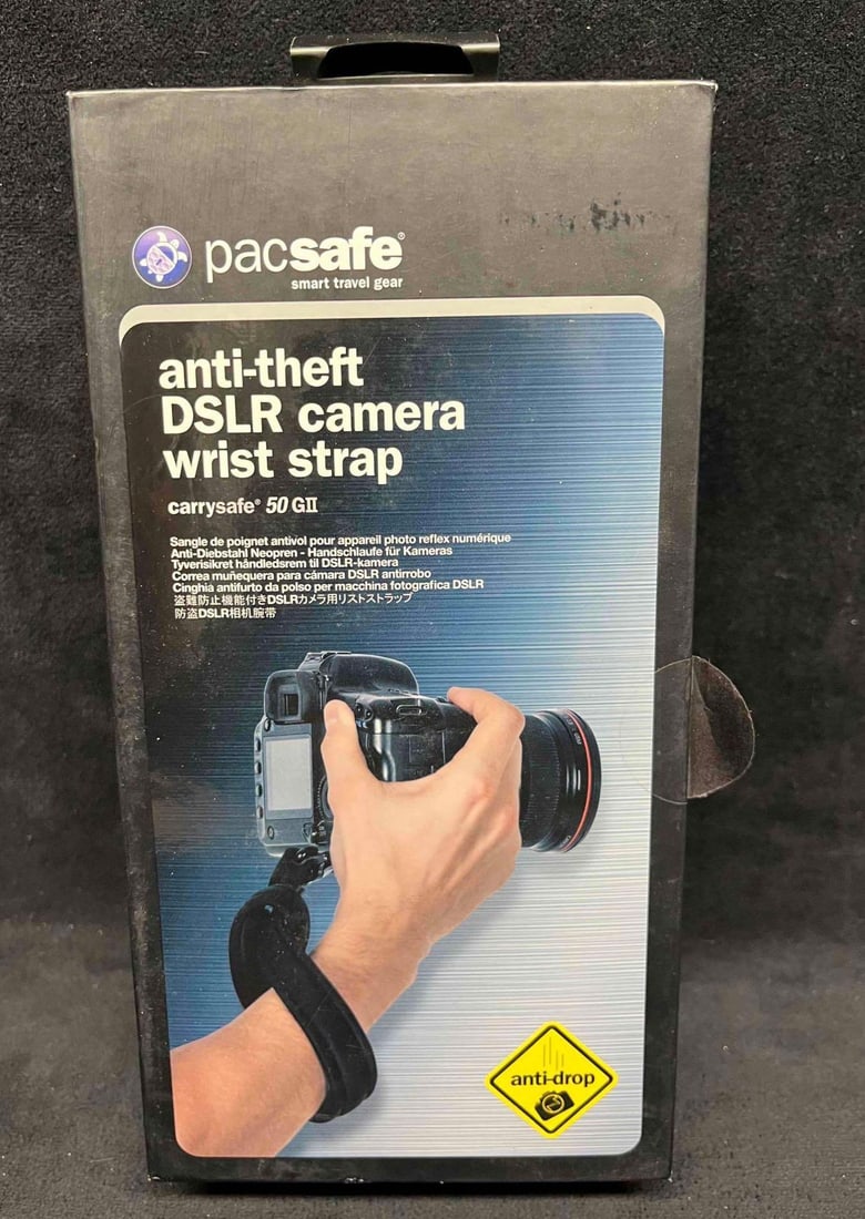 PacSafe Anti-Theft DSLR Camera Wrist Strap In Original Box (4): This lot contains a PacSafe Anti-Theft DSLR Camera Wrist Strap In Original Box (4). The box is approx 4 1/2" x 2 1/4". Total weight is 0.6lbs. Overall the camera strap is in good condition as 