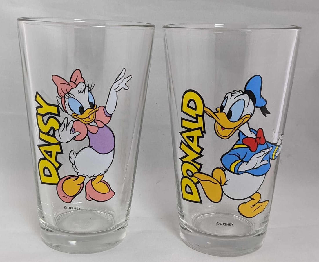Libbey Glass Disney Donald And Daisy Pint Glasses: Two Disney pint glasses by Toledo, Ohio glass-maker Libbey Glass. Each glass has a different Duck character and is approx 3" x 3" x 6" and together they weigh 1.93lb. Both are in good, use