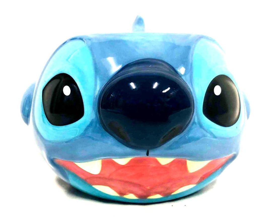 Disney Store Exclusive Stitch China Mug 3D Raised Face: This lot contains a Disney Store Exclusive Stitch China Mug 3D Raised Face from Disney's Lilo & Stitch. It is approx 5 1/2" x 4 1/2" x 4" and weighs about 0.7lbs. Overall the mug i
