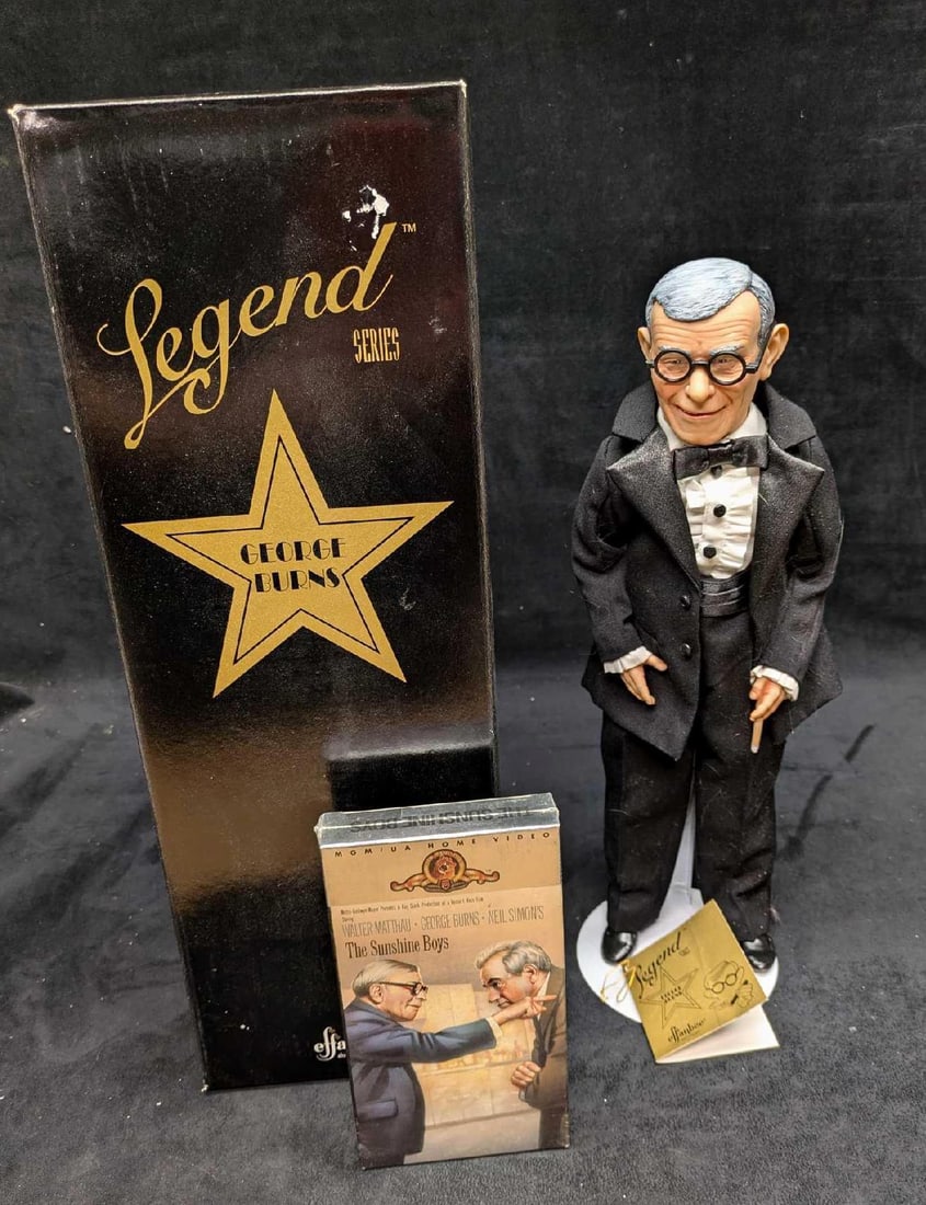 Effanbee Legends Series George Burns Doll With Movie: Effanbee Legends Series George Burns Doll With Movie. The porcelain doll comes with a stand and an unopened VHS copy of the "Sunshine Boys". The doll's eye glasses is missing one of its te